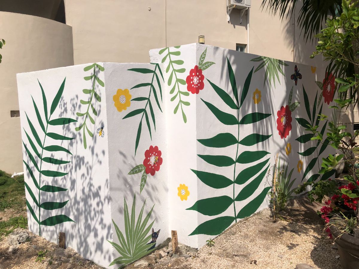 Courtyard wall mural of green ferns and red and yellow flowers — hand-painted mural in Playa del Carmen, Mexico by Scout Hill Co